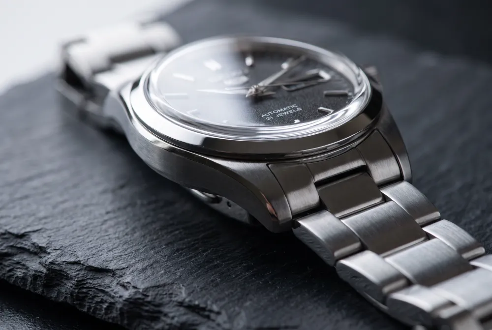 Nano Banana Pro macro photo of a steel wristwatch on slate with crisp brushed finishing